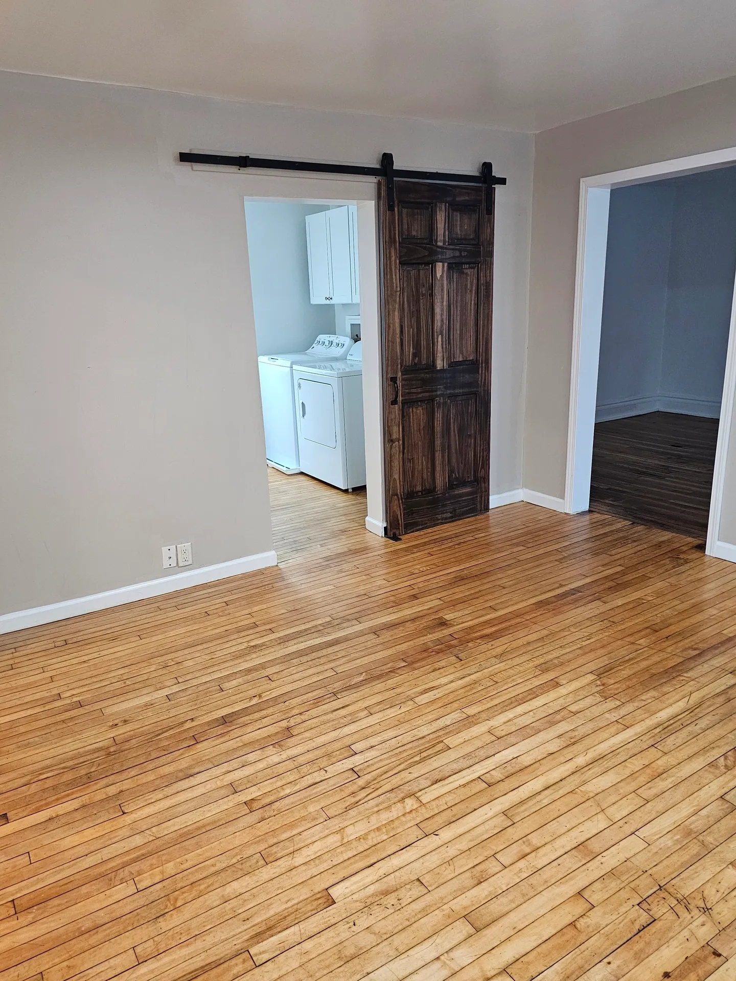 Room with wooden floor and sliding door.
