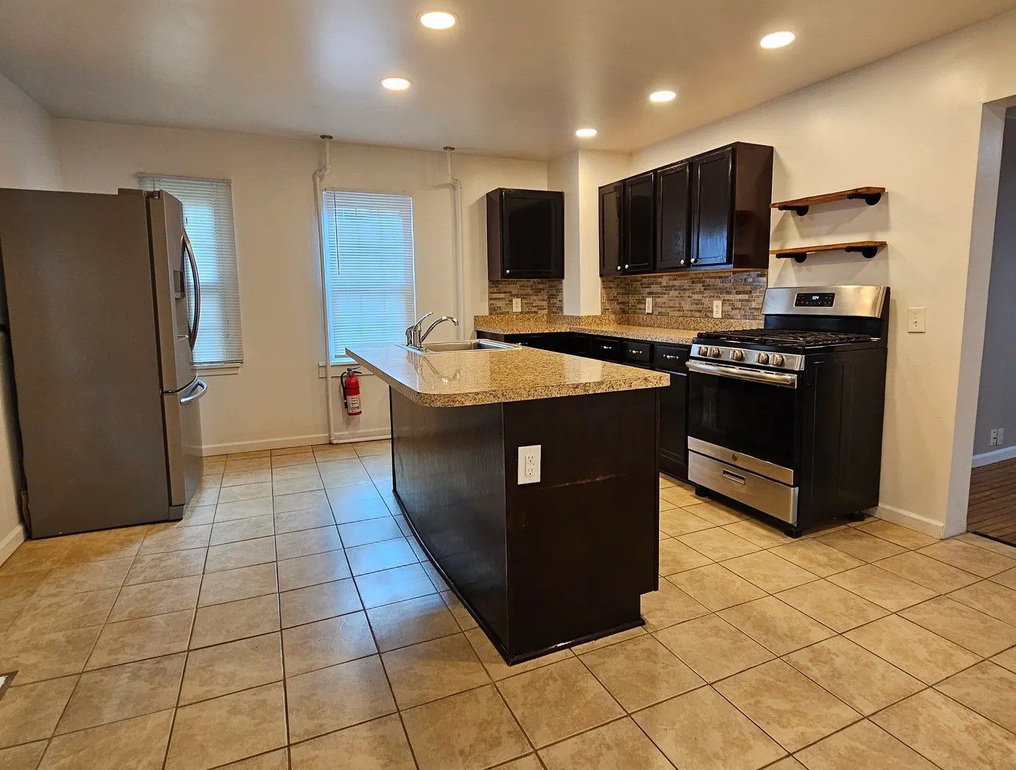 A kitchen with brown cabinets and tile floors.